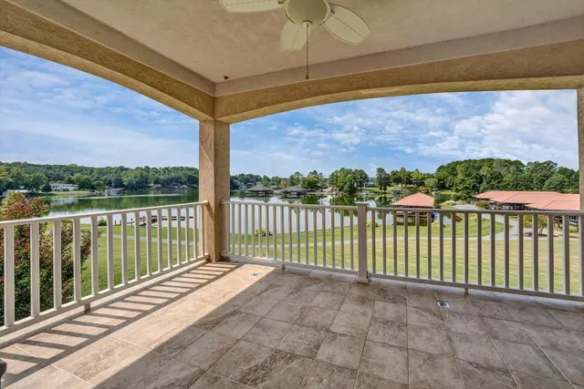 Lake view from a covered villa deck, looking across open water toward wooded shoreline